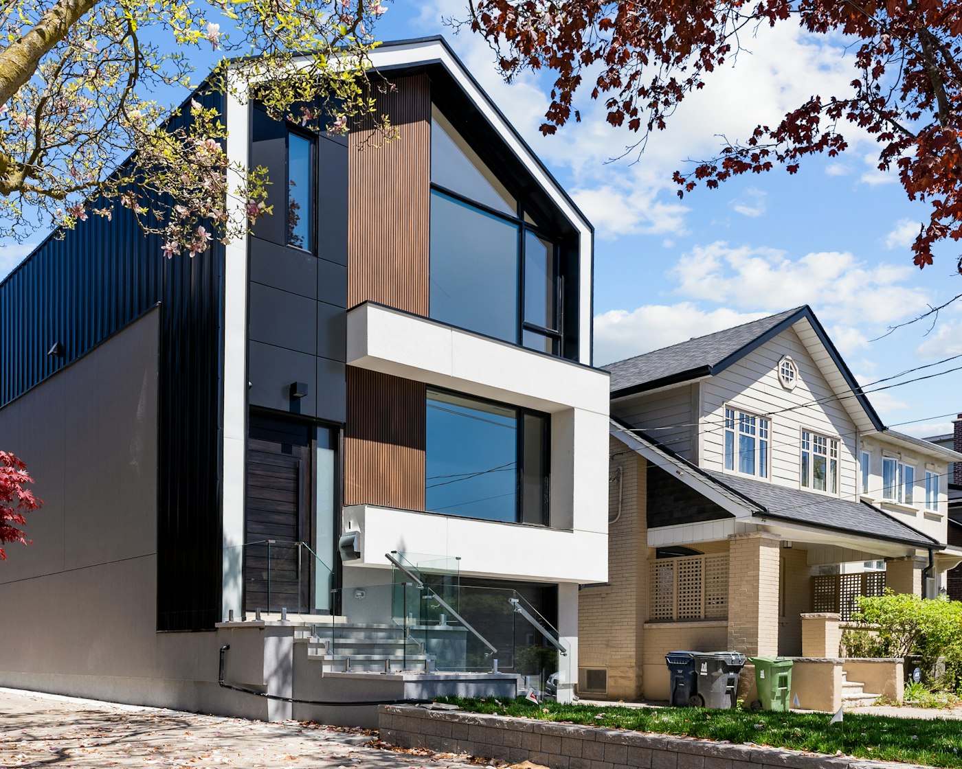 New multi-residential building sitting alongside an older home on an established street